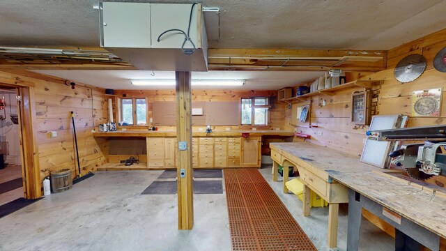 basement featuring wooden walls and a workshop area