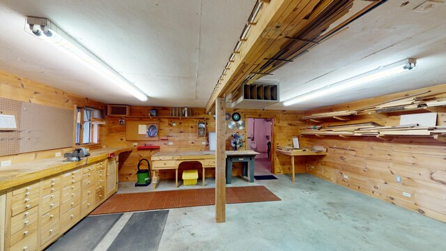 basement with wooden walls and a workshop area