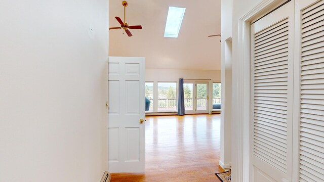 corridor with a skylight and light wood-type flooring