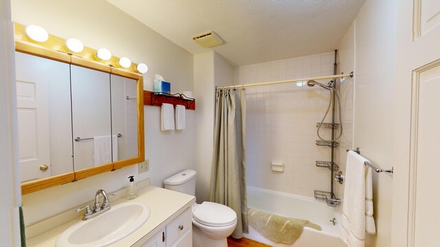 full bathroom featuring vanity, a textured ceiling, toilet, and shower / bath combo