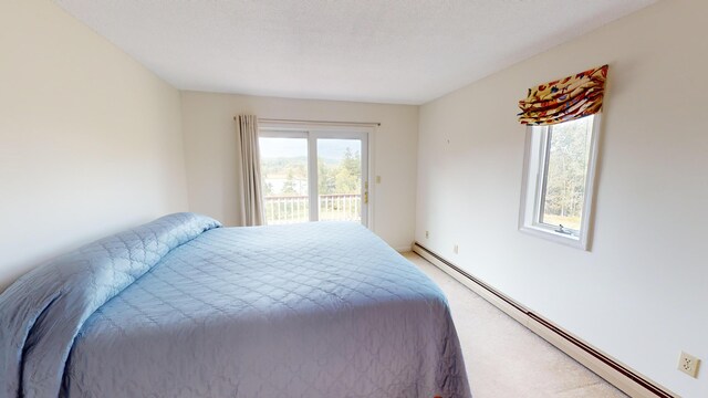 carpeted bedroom featuring baseboard heating and access to exterior