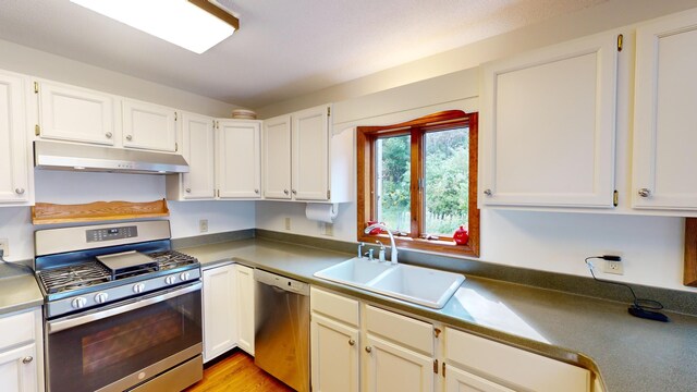 kitchen with stainless steel appliances, light hardwood / wood-style floors, sink, and white cabinets