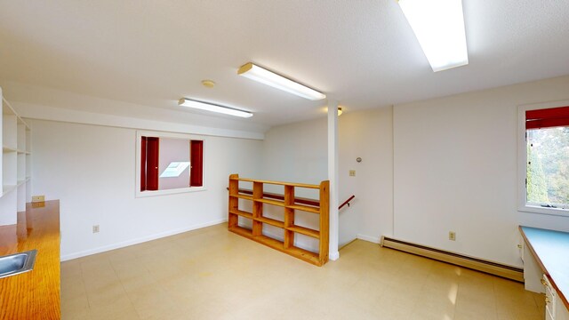 basement with a baseboard heating unit and sink