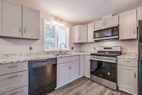 kitchen with light stone countertops, appliances with stainless steel finishes, sink, light hardwood / wood-style flooring, and white cabinets