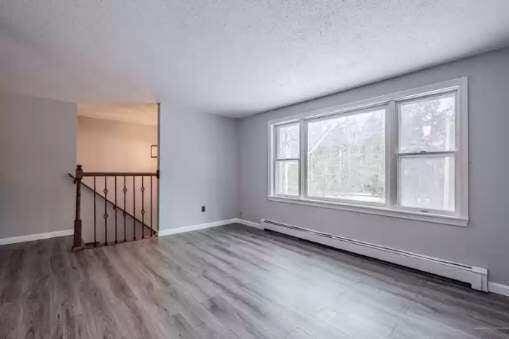 spare room featuring dark wood-type flooring and a baseboard heating unit