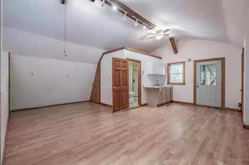 additional living space with ceiling fan, light hardwood / wood-style floors, and vaulted ceiling