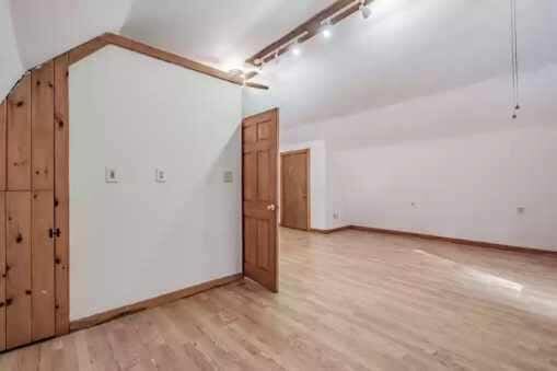 bonus room featuring light wood-type flooring and vaulted ceiling