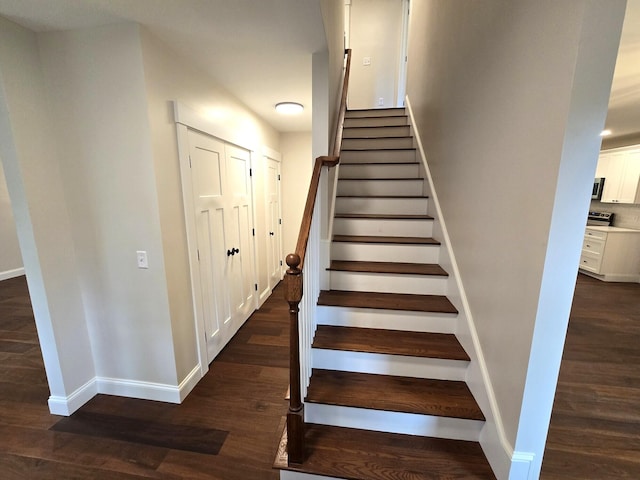 stairway featuring wood finished floors and baseboards