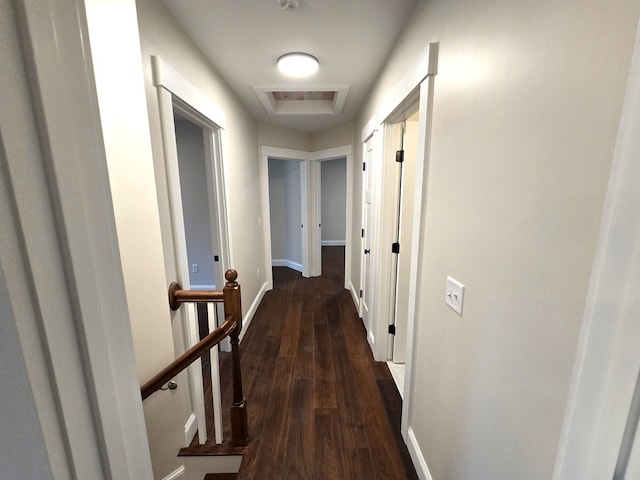 hall with attic access, wood finished floors, an upstairs landing, and baseboards