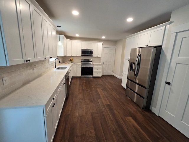 kitchen featuring dark wood-style flooring, stainless steel appliances, recessed lighting, backsplash, and a sink