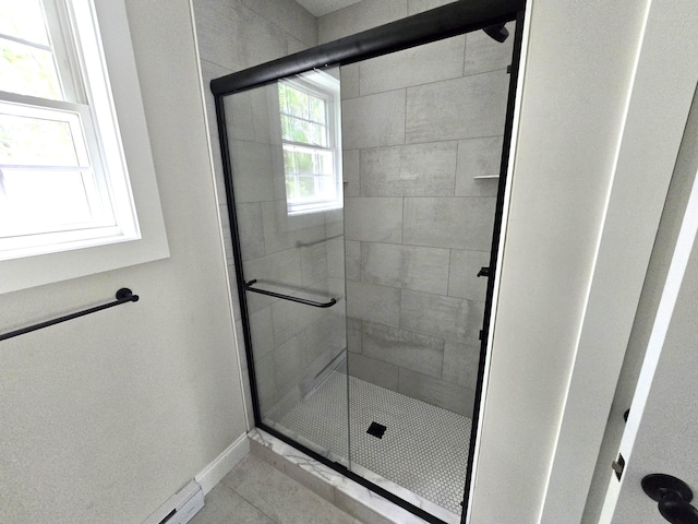 bathroom with tile patterned flooring, a shower stall, and baseboards