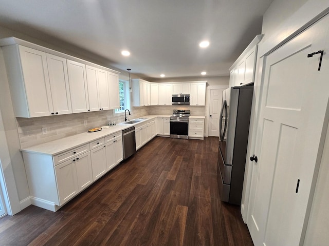 kitchen featuring light countertops, backsplash, appliances with stainless steel finishes, and dark wood-type flooring