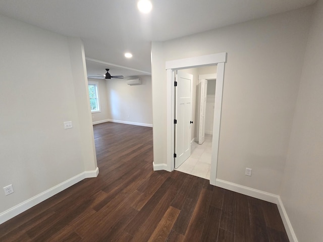 unfurnished room with a wall unit AC, recessed lighting, ceiling fan, wood finished floors, and baseboards