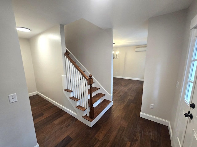 staircase featuring a wall mounted air conditioner, baseboards, and wood finished floors