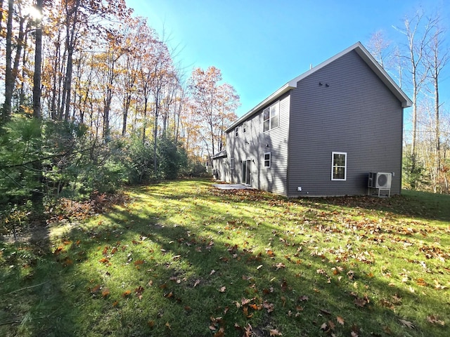 view of side of home with ac unit and a lawn