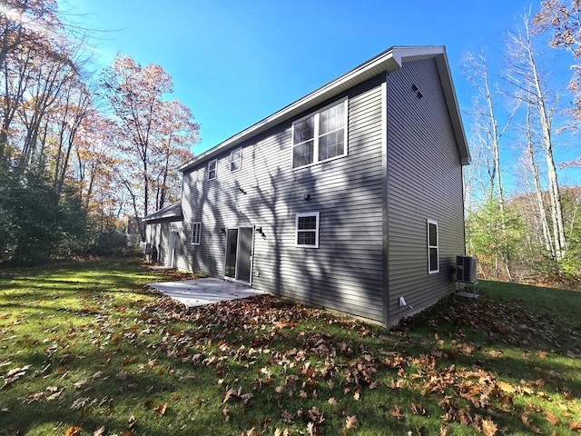 back of property featuring a lawn, central AC, and a patio