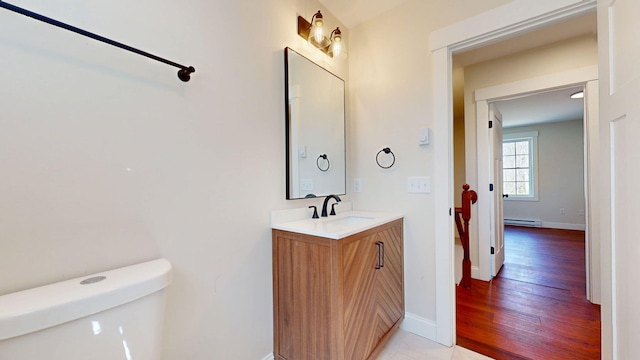 12 Country Dr, Old Orchard Beach, ME 04064 - half bathroom with toilet, a baseboard radiator, vanity, baseboards, and wood finished floors