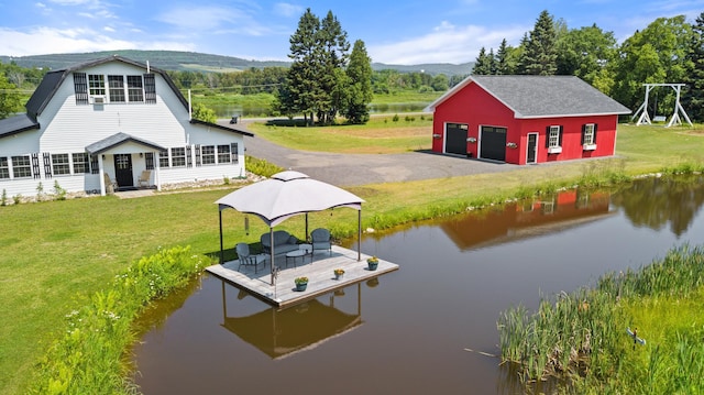 view of dock featuring a water and mountain view and a lawn