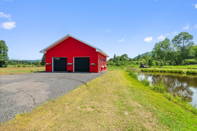 garage with a water view and a yard