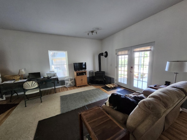 living room featuring hardwood / wood-style floors, a wood stove, and french doors