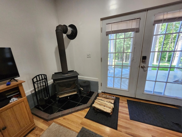 entryway featuring french doors, a wood stove, and light hardwood / wood-style flooring