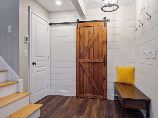 mudroom featuring a barn door, wood walls, and dark hardwood / wood-style floors