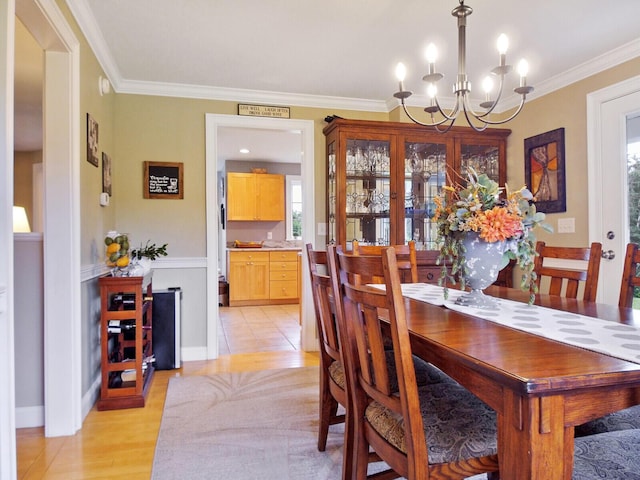 dining space featuring ornamental molding, light hardwood / wood-style floors, and a notable chandelier