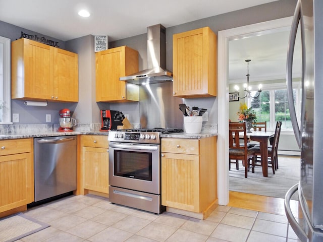 kitchen featuring wall chimney exhaust hood, light brown cabinets, appliances with stainless steel finishes, and an inviting chandelier