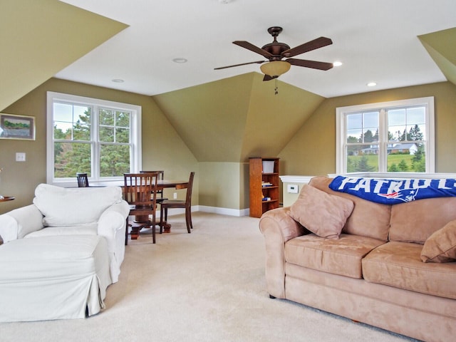 living room with light carpet, a wealth of natural light, vaulted ceiling, and ceiling fan