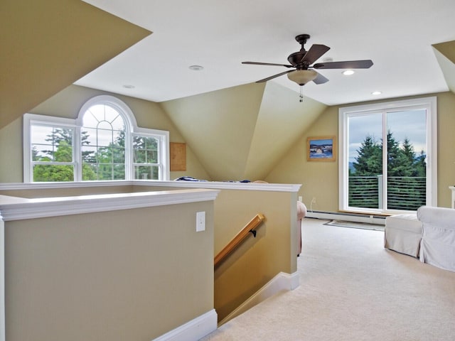 interior space with light colored carpet, a healthy amount of sunlight, lofted ceiling, and a baseboard heating unit