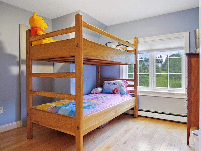 bedroom with a baseboard radiator and light hardwood / wood-style floors