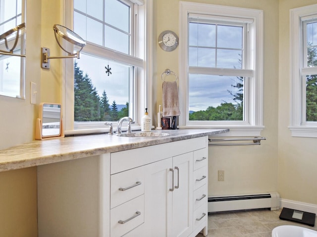 bathroom with tile patterned flooring, vanity, and baseboard heating