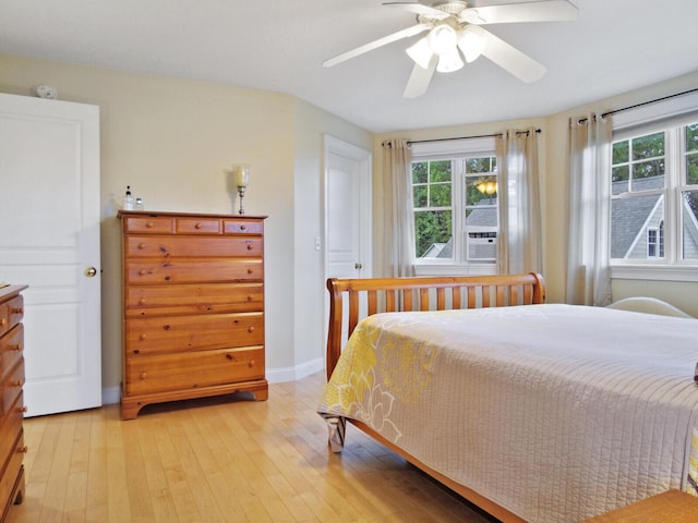 bedroom featuring multiple windows, light hardwood / wood-style floors, and ceiling fan