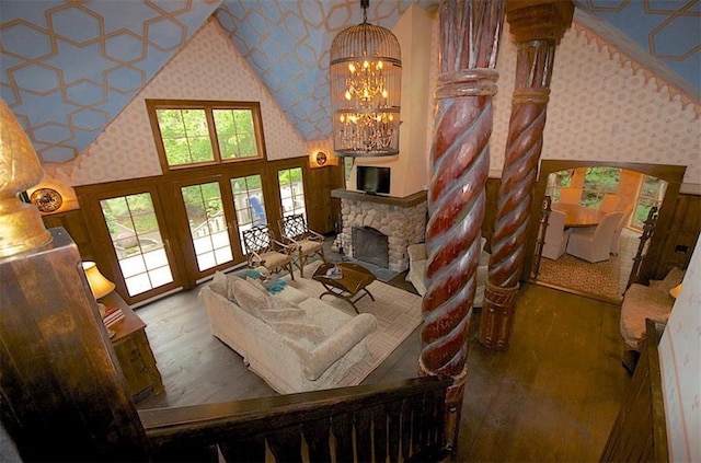 living room with hardwood / wood-style flooring, high vaulted ceiling, an inviting chandelier, and a fireplace