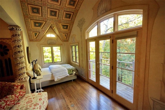 bedroom with wood-type flooring, access to outside, french doors, and vaulted ceiling