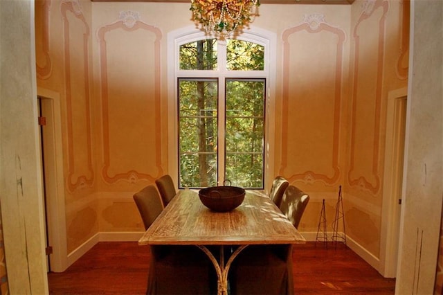 dining space featuring dark hardwood / wood-style flooring and an inviting chandelier