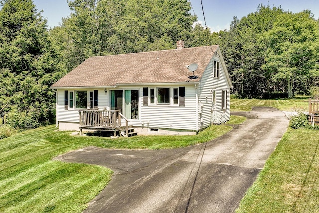 view of front of house featuring driveway, a shingled roof, a chimney, and a front lawn