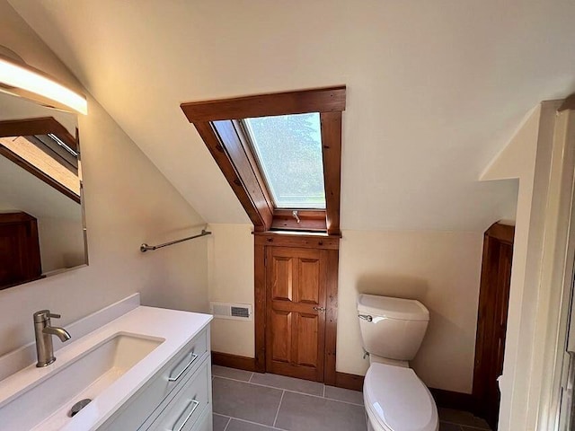 bathroom featuring vaulted ceiling with skylight, vanity, and tile patterned flooring