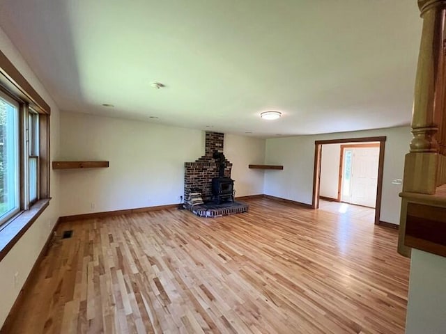 unfurnished living room featuring light hardwood / wood-style floors and a wood stove