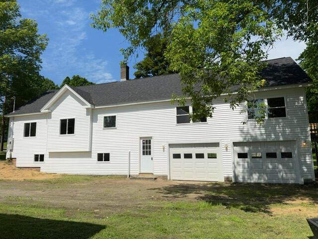 back of property featuring a yard and a garage