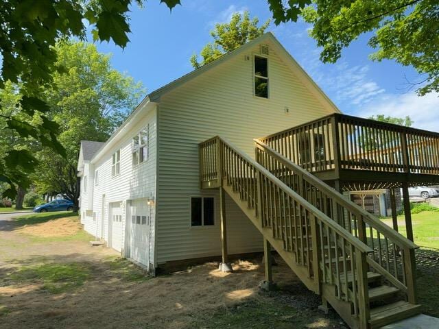 rear view of house with a garage and a wooden deck