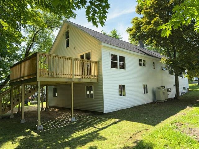 rear view of house featuring a yard and a wooden deck