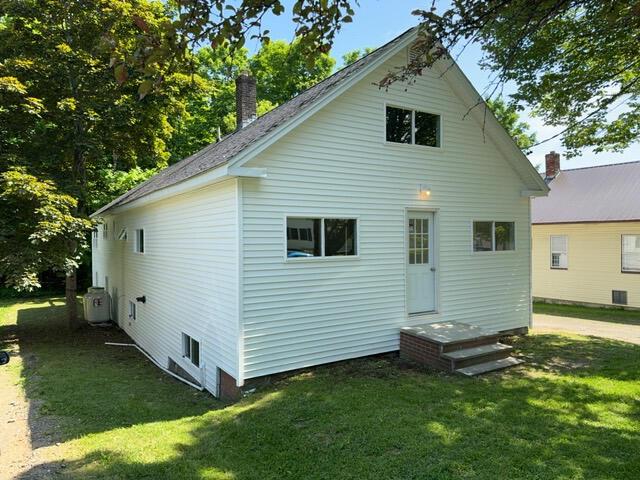 rear view of property featuring a yard