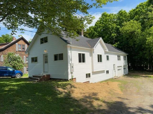 rear view of house featuring a lawn