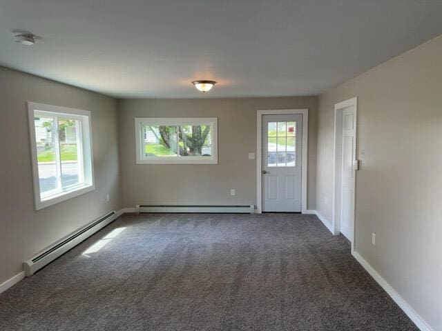 carpeted spare room featuring baseboard heating