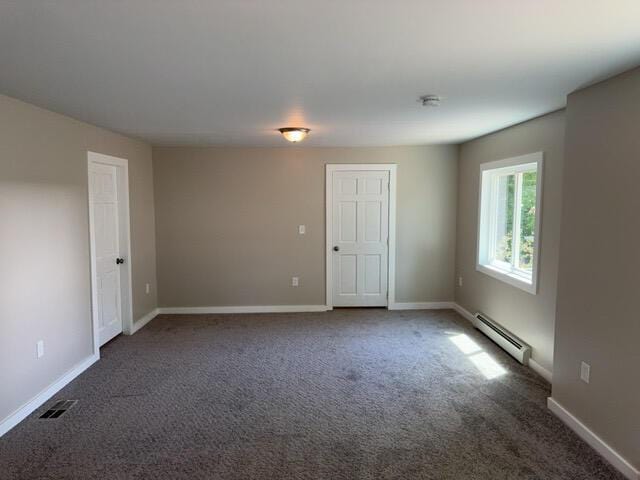 carpeted spare room featuring baseboard heating