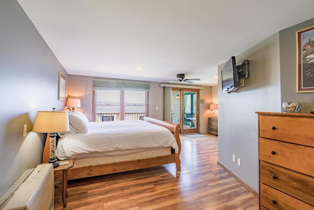bedroom with access to exterior, light wood-style floors, and baseboards