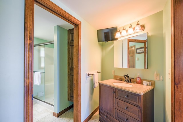 bathroom with a stall shower, baseboards, and vanity