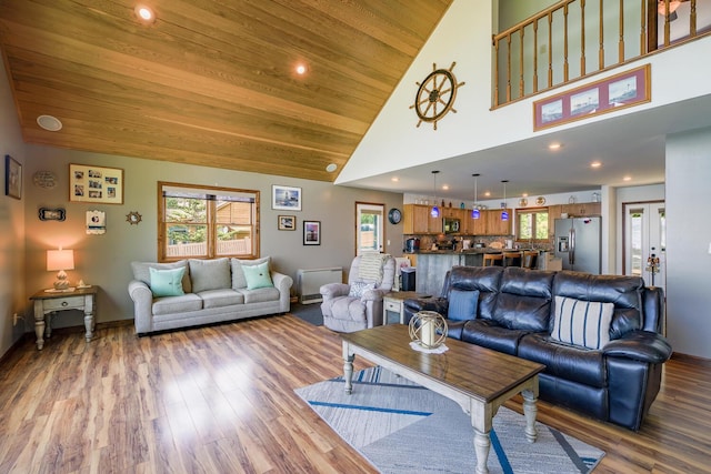 living room featuring baseboards, wood ceiling, wood finished floors, high vaulted ceiling, and recessed lighting