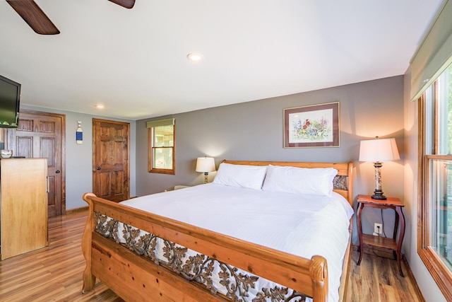 bedroom with light wood-style floors, ceiling fan, multiple windows, and recessed lighting